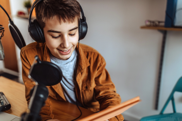 Un enfant parlant dans un micro, s'essayant au journalisme radio